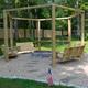 Firepit area with swinging benches and pergola-style frame — shows a communal amenity on the campground grounds (matches bonfire/amenity images on the site).