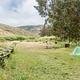A large grassy field with multiple campsites that are roughly 11 feet apart.