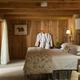 Interior bedroom of a log cabin with rustic wood walls and furnishings — useful for illustrating cabin accommodations listed on the site.