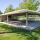 Large covered pavilion with picnic tables on grassy area — demonstrates a key amenity and gathering space listed on the amenities page.
