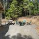 Cabin-side seating and firepit area adjacent to a cabin — useful close view of cottage amenities and grounds (from the Rates page gallery).
