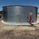 Close view of a large corrugated metal water tank located on-site — documents utilities/infrastructure important to the RV park.