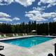 Outdoor swimming pool with lounge chairs and fenced deck — clearly a campground amenity; image is used as the site hero/background for the Bangor/Holden KOA page so it is on-property.