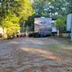 Gravel RV site with a travel trailer visible — shows the campground's RV pitches and typical site layout (site gallery images).