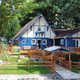Blue and white building with a wooden deck, a golf cart, and an American flag.