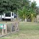 Fenced grassy area with nearby RVs and landscaping — depicts the dog-friendly area/grounds and campsite proximity (from homepage/gallery).