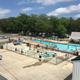 High-detail view of the main outdoor swimming pool with people and surrounding facilities — demonstrates a major on-site amenity and activity area.