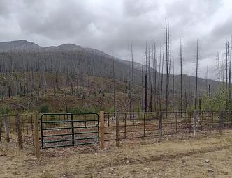 Outside of corral on a cloudy day with mountain in background