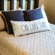 Lakeshore vacation home rental bed with "On Lake Time" pillow at Noquebay Resort.