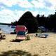 Clear, high-resolution sandy beach view with lounge chairs and the lake — shows the property’s beachfront recreation area; sourced from the site's Highlights page (about the campground beach).