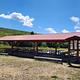 Many picnic benches under a pavilion 