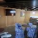 Interior clubhouse/lounge area with seating, TV and bar/kitchen — useful to show indoor guest facilities.