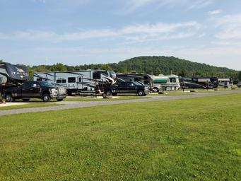 Wide-angle ground-level view of multiple RV pull-through sites and surrounding lawn area — demonstrates typical RV accommodation and site spacing; from the property homepage gallery images.