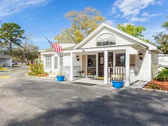 Exterior of the clubhouse/office building with porch and flag — shows on-site facility and matches images used on the property's page.