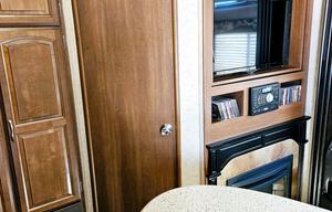 Large RV with outdoor kitchen, fireplace, and TVs