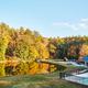 Ground-level view of the pond, pool and adjacent building with tree-lined backdrop — good scenic amenity shot from the resort’s page.