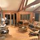 Interior living-room of a cabin/lodge (wood paneling, beams, seating) — lodging page image showing on-site accommodation common area useful for property gallery.