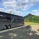 Clear exterior view showing a paved RV pad with a large motorhome, picnic table and a distinctive flat-topped mountain in the background — useful site overview from the park’s Rv Park page.