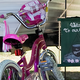 Close-up under an RV of bicycles, toys and a small ‘Welcome to our Camp’ sign — useful for conveying family-friendly campsite setup and atmosphere (homepage slide).