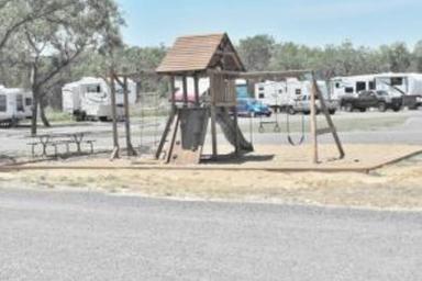 Playground with picnic table and RV sites visible behind it — shows family-friendly amenities and adjacent RV parking consistent with the property's gallery.