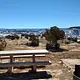Picnic table and fire ring with snowy canyons in background