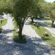 Ground-level view of tree-lined RV pads with picnic tables and hookups — useful campsite detail and feel of the grounds (gallery page).