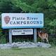 A deer stands warily near the Platte River campground entrance sign