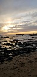 Sunset beach scene used repeatedly on the site as a background image; depicts the nearby shoreline and scenic views guests can expect (useful scenic photo for the property gallery).