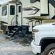 Ground-level photo of an RV site with paved pad, landscaping and tow vehicle — shows typical RV pitch and site finish. Image is from the resort homepage slider, supporting that it depicts on‑site accommodation.