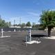 Wide view of paved RV hookup pedestals and a tree in the middle of the lot showing individual RV pads and utilities — useful site-specific image from the property gallery.