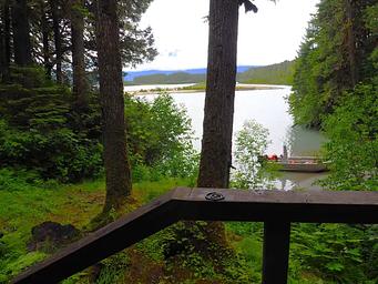 View from entrance of Mount Flemer Cabin showing trees, water and a small boat