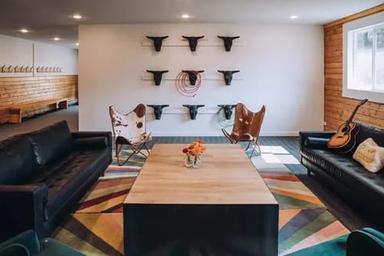 Interior lounge/common room with seating and ranch-themed decor — useful to show indoor guest facilities and accommodations available at the ranch.