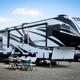 Clear photo of RV sites with a large fifth-wheel parked on a gravel pad, outdoor chairs/tables and utility pedestals — matches RV park accommodations shown on the Cal Expo RV Park page (social image for the RV Park).