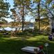 Riverside campsite view showing an RV, picnic table, chairs, lawn and river frontage — clear on-property campsite photo used on the homepage to illustrate camping along the Squamscott River.