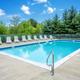 Outdoor swimming pool with lounge chairs and fencing — depicts the campground’s recreational facility (pool) seen on the property page.