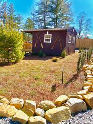 Small cabin or park building set within landscaped grounds and rock edging — from the property's Gallery page, useful to show on-site structures and landscaping.