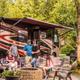 Hero photo showing an on‑site RV parked at a campsite with a fire ring, seating area and trees — clear property scene used on the campground’s main page (hero image).