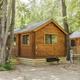 Wood cabin exterior among trees — clear photo of one of the campground’s rental cabins shown on the property pages.