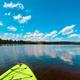 Wide lakeshore view with a kayak in foreground — clear photo of Ayers Lake waters and shoreline; matches attractions/gallery images on the property site (shows on-site lake recreational area).
