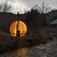 Barrel sauna glowing at dusk beside the private river at Zen Zion