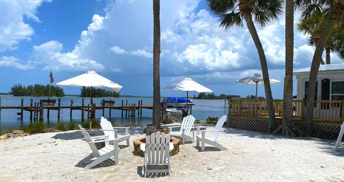 Waterfront seating and firepit area facing the bay with docks in background — highlights waterfront amenities and guest gathering space (shown on homepage/amenities).
