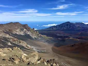 color cinders within a crater and mountain in the distance