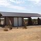 A long covered pavilion provides a shaded picnic area in the desert