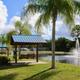 Pond and fountain on the grounds with covered benches and palm trees — clear scenic facility photo used on the site’s community pages.