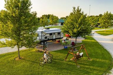 Aerial/overview of an RV pull‑through site with green space, picnic area and a swing — shows campground layout and typical RV site amenities (listed under the campground’s 'ways to stay' images).