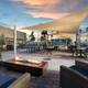 Outdoor lounge/firepit seating area with shade sails and tables — shows another on-site gathering space and resort amenities shown on the site.