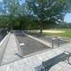 Paved bocce courts with benches and open lawn beyond — depicts another on-site recreational amenity and hardscape improvements; from the campground’s gallery page.