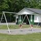 Playground swings in front of a facility building — shows on-site recreation and family facilities (from the Camping photo gallery page).