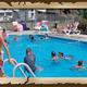 Clear photo of the on‑site swimming pool with lounge chairs and campers in the water — shows a core campground amenity. Source page is the park homepage image slider, supporting property context.