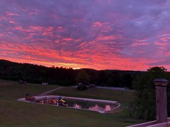 Sunset view over the play pond and fields from the homepage — attractive scenic shot that highlights campground atmosphere and location.